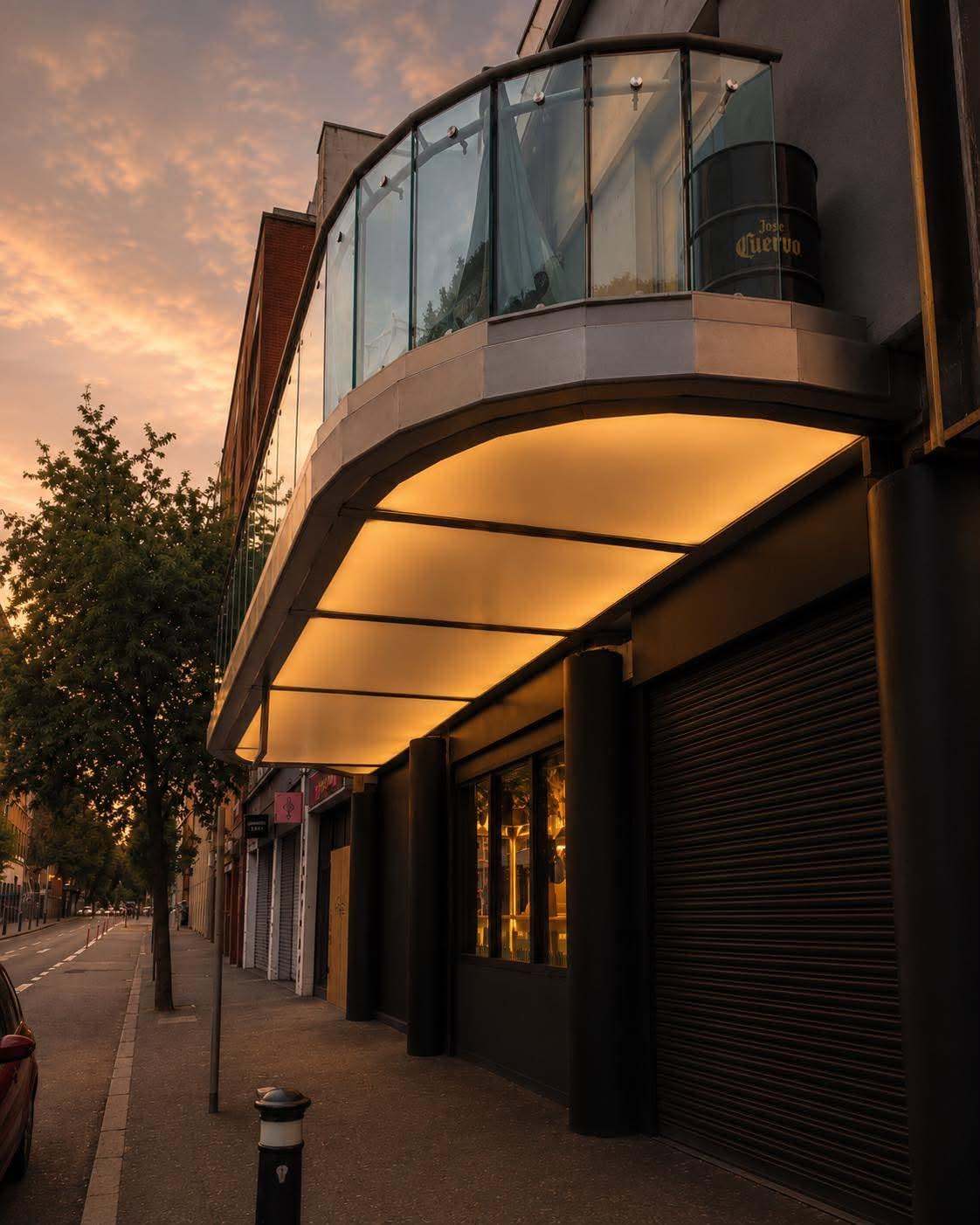 The glass balcony over Upper Arthur Street at dusk